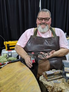 My blacksmithing teacher, showing off the bottle openers that he, I and the other student made.